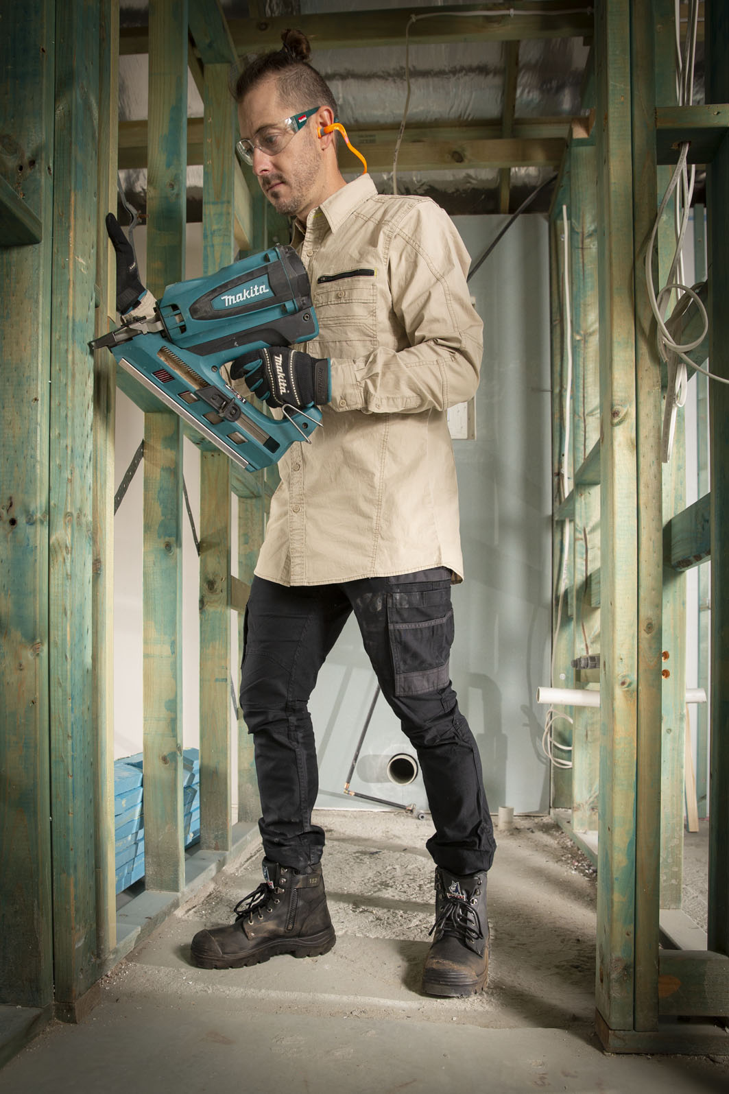 Workman using staple gun with black boots
